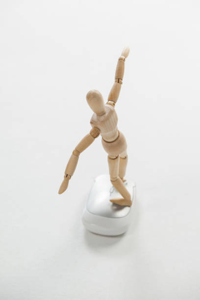 istock Wooden figurine standing with arms spread on a mouse 649587288