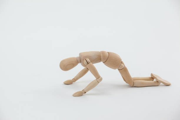 istock Wooden figurine exercising on floor 649587310