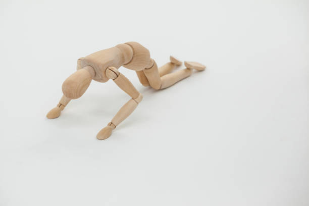 istock Wooden figurine exercising on floor 649587370