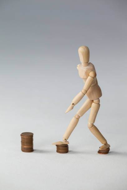 istock Wooden figurine stepping on stack of coins 649587396