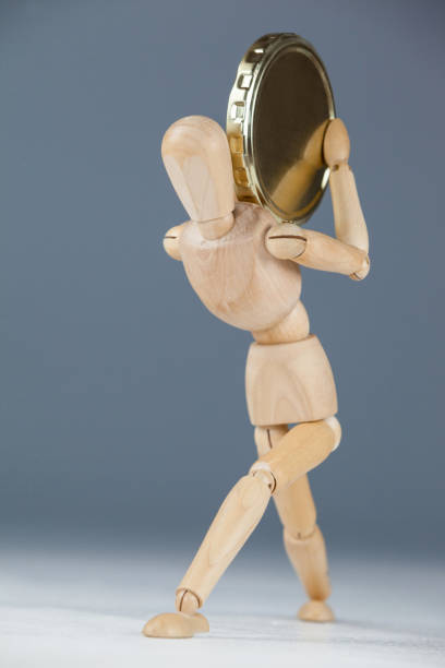 istock Wooden figurine holding a gold coin 649587620