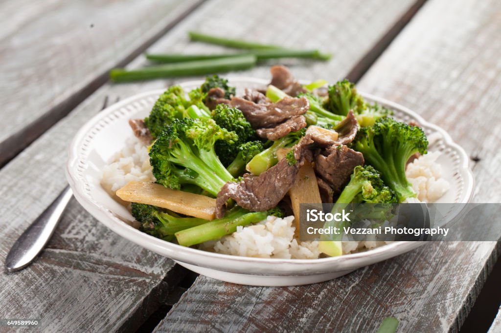 Beef N’ Broccoli Stir Fry horizontal shot Beef N’ Broccoli Stir Fry on light weathered wood with green beans to side horizontal shot Beef Stock Photo