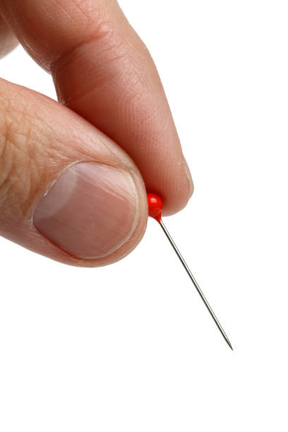 istock hand holding a pin with a red head 649590368