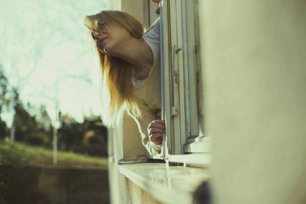 istock Girl taking fresh air from her window 649596732