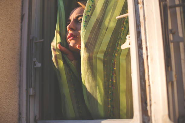 istock Girl taking fresh air from her window 649596810