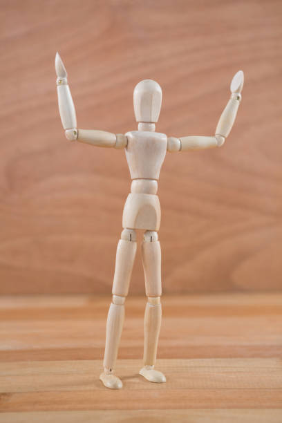 istock Wooden figurine standing with hand raised 649597586