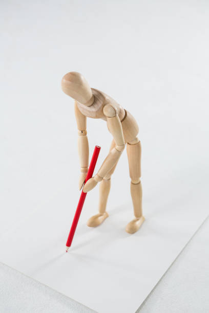 istock Wooden figurine drawing on a paper 649601392