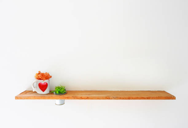 istock Wooden shelf on white wall with green plant. 649604528