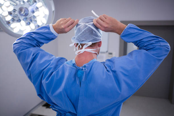 Surgeon tying surgical mask in operation room at hospital