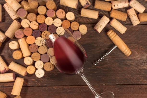 istock Glass of red wine and corks on dark background 649608530