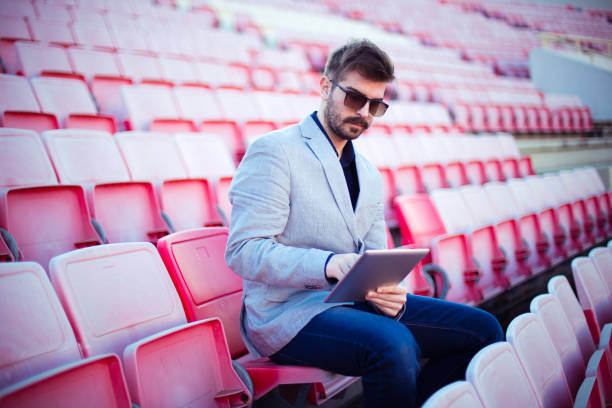 istock Businessman on tribune using tablet for live betting 649611734