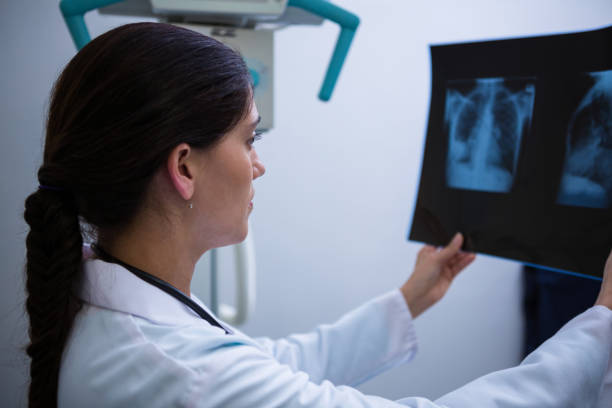 istock Female doctor examining x-ray report 649615646