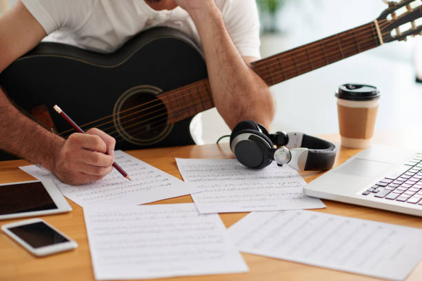 Man working on song Guitar player writing music for new song composer photos stock pictures, royalty-free photos & images