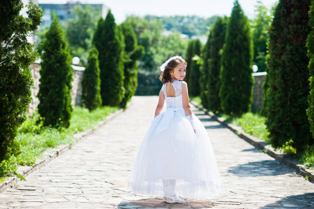 Portrait Of Cute Little Girl On White Dress And Wreath Of First Holy  Communion Background Thuja Alley Stock Photo - Download Image Now - iStock