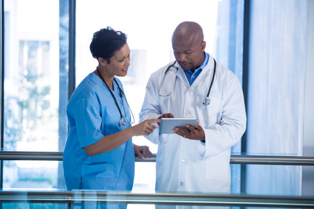 istock Male doctor and nurse using digital tablet in corridor 649625276