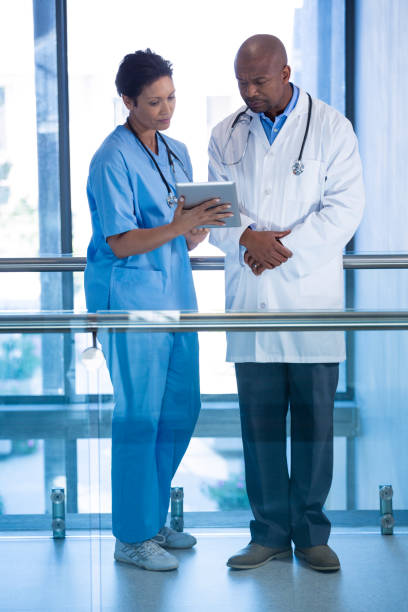 istock Male doctor and nurse using digital tablet in corridor 649625334