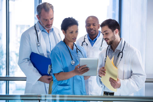istock Male doctors and nurse using digital tablet in corridor 649625364