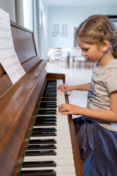 istock Girl practising playing the piano 649630880
