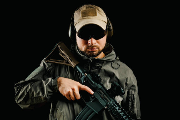 istock man in cap holding assault rifle 649634158