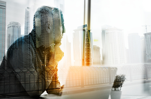 Shot of a businessman using a laptop in his office superimposed over a cityscape