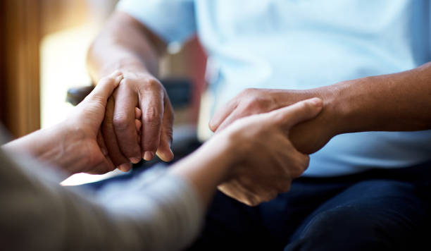 un confort dans le cas de besoin - human hand old senior adult holding hands photos et images de collection