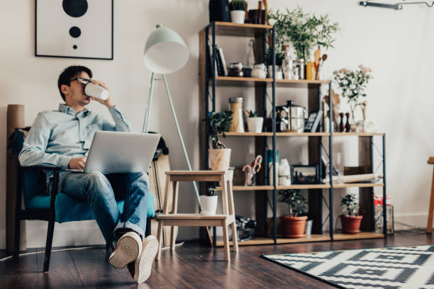 istock Young man at home surfs the internet and drinking coffee 649650202