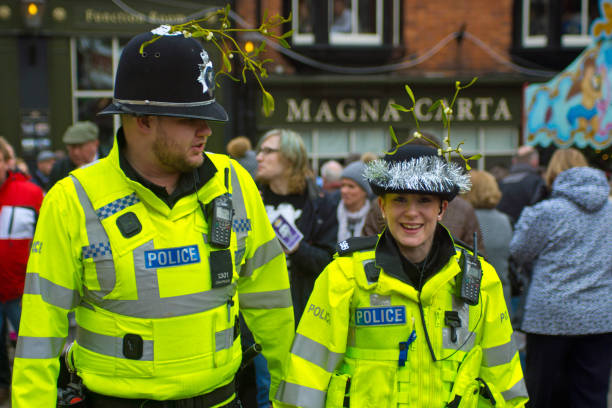 Smiling Policeman at Christmas English police on the beat at the Lincoln Christmas Market. they are joining in the festive mood with mistletoe and tinsel around their helmets. the female officers is looking at the camera and smiling. east anglia stock pictures, royalty-free photos & images