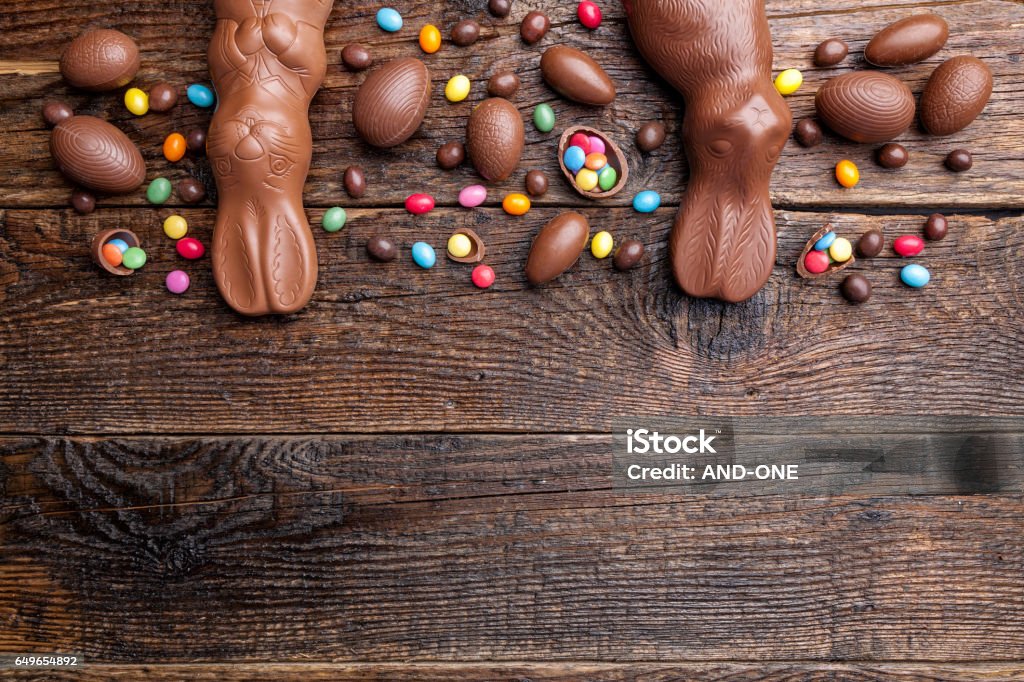 Chocolate Easter bunny and eggs on wooden background Delicious chocolate Easter bunny and eggs on wooden backgroundDelicious chocolate Easter bunny and eggs on wooden background Animal Stock Photo