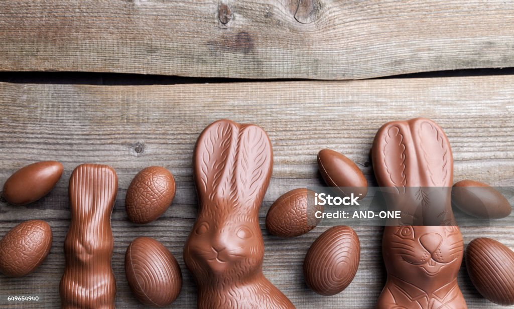 Chocolate Easter bunny and eggs on wooden background Delicious chocolate Easter bunny and eggs on wooden backgroundDelicious chocolate Easter bunny and eggs on wooden background Animal Stock Photo