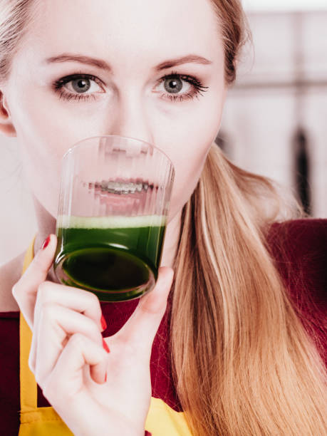 istock Woman in kitchen holding vegetable smoothie juice 649673258