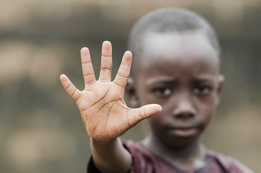 Little african boy showing palm as stop sign for racism and war