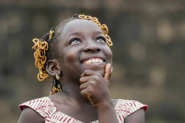 petite fille africaine pensant à son avenir sur le continent noir - assistance child community unity photos et images de collection