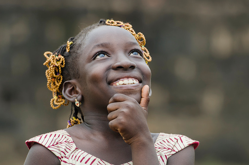 Young african girl with traditional accessories in hair looking at sky