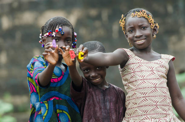 A B C - Education Symbol by Little African Children African children holding small colored letters in front of camera poverty child ethnic indigenous culture stock pictures, royalty-free photos & images