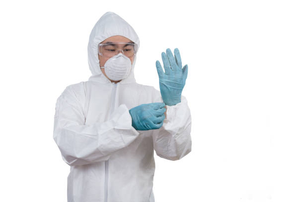istock Asian Chinese scientist in protective wear putting on gloves 649675770