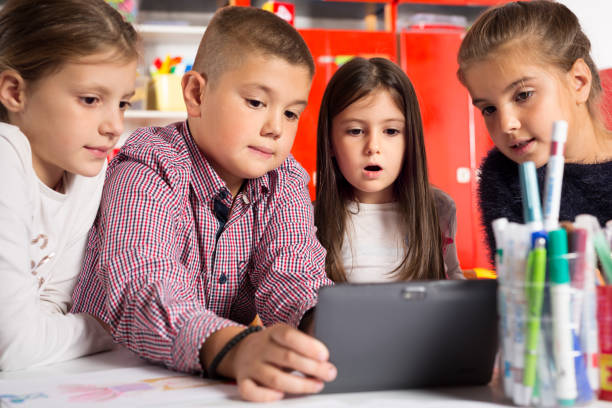 istock Group of school kids with tablet pc in classroom 649681306