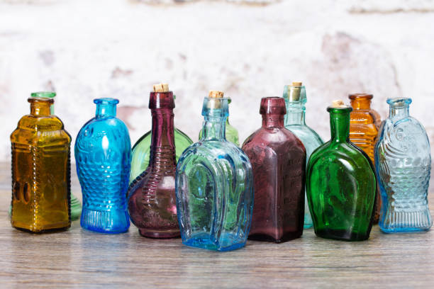 Coloured glass bottles on a rustic background stock photo