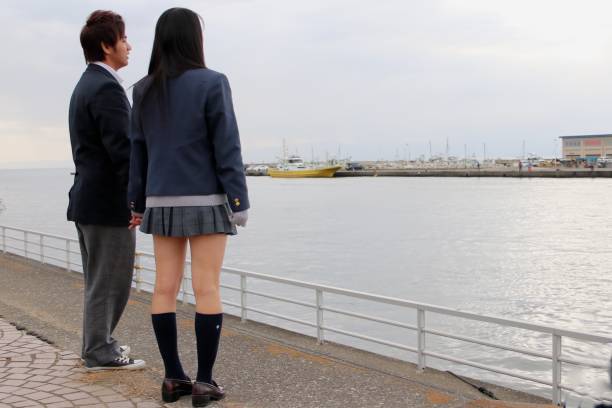 istock HIgh School Student Couple Standing at Beach Side 649695786