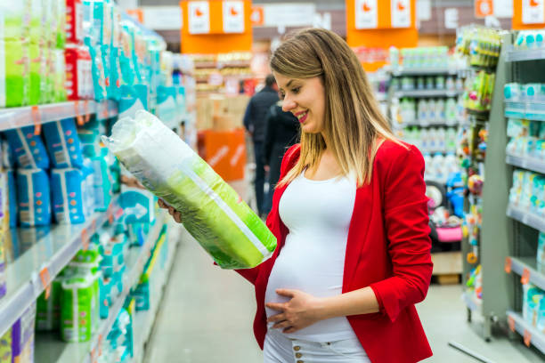 妊娠中の女性の写真はスーパーでおむつを買う - diaper shopping human pregnancy supermarket ストックフォトと画像