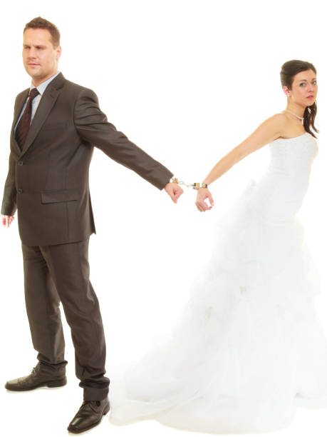 istock Bride and groom in handcuffs wearing wedding outfits 649699084