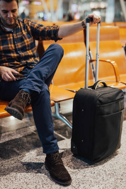 istock Man in departure lounge using smart phone 649699330