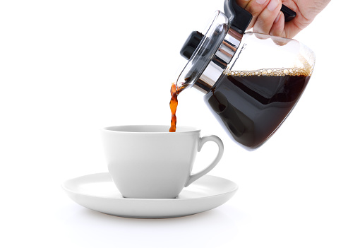 Pouring coffee on a cup isolated on white background