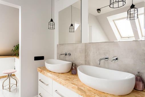Minimalist bathroom with two sinks and wooden vanity top