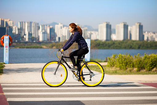 SEOUL, KOREA - APRIL 24, 2015: A girl cycling at a racreation park zone on the bank of Hangang river in Seoul, Korea
