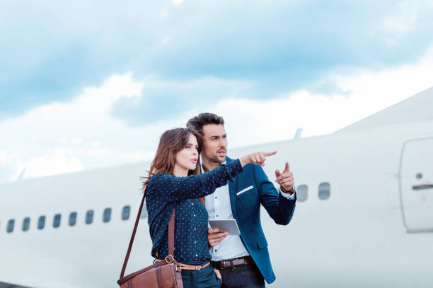 istock Business colleagues standing in front of airplane. 649730344