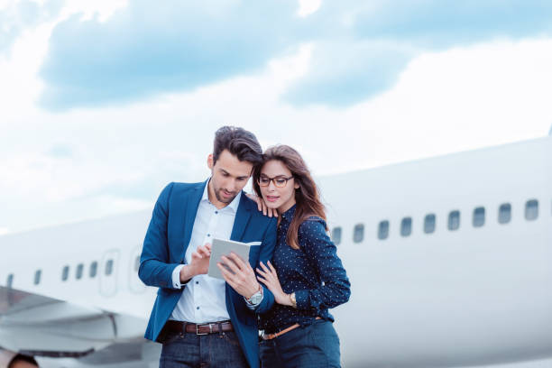 istock Business colleagues using a digital tablet in front of airplane. 649731010