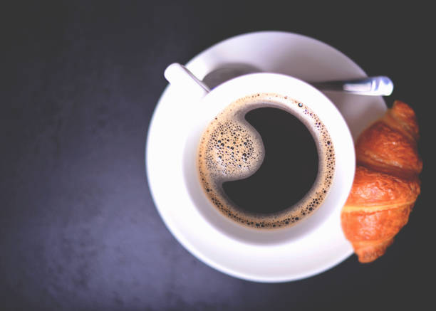 istock Croissant and cup of coffee on black background 649735586
