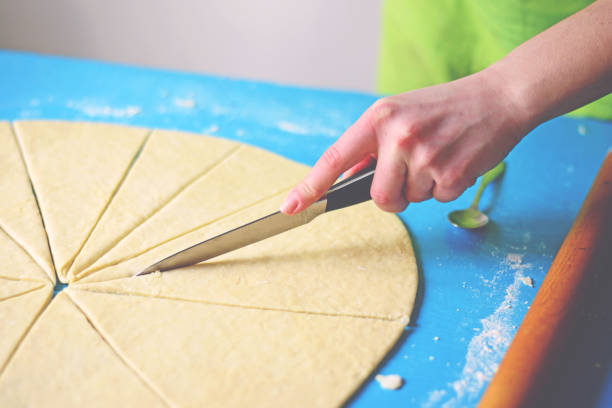 istock Cutting raw dough in flour with a knife 649735658