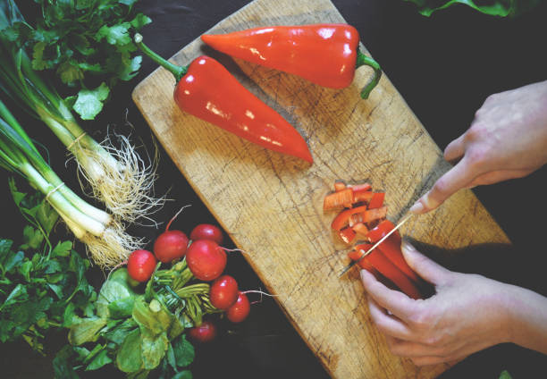 istock Female slicing pepper for salad. Close up chef cutting vegetables. 649735718