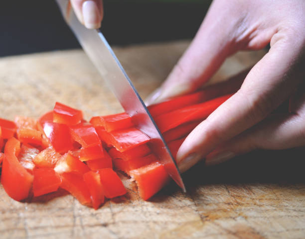 istock Female slicing pepper for salad. Close up chef cutting vegetables. 649735732